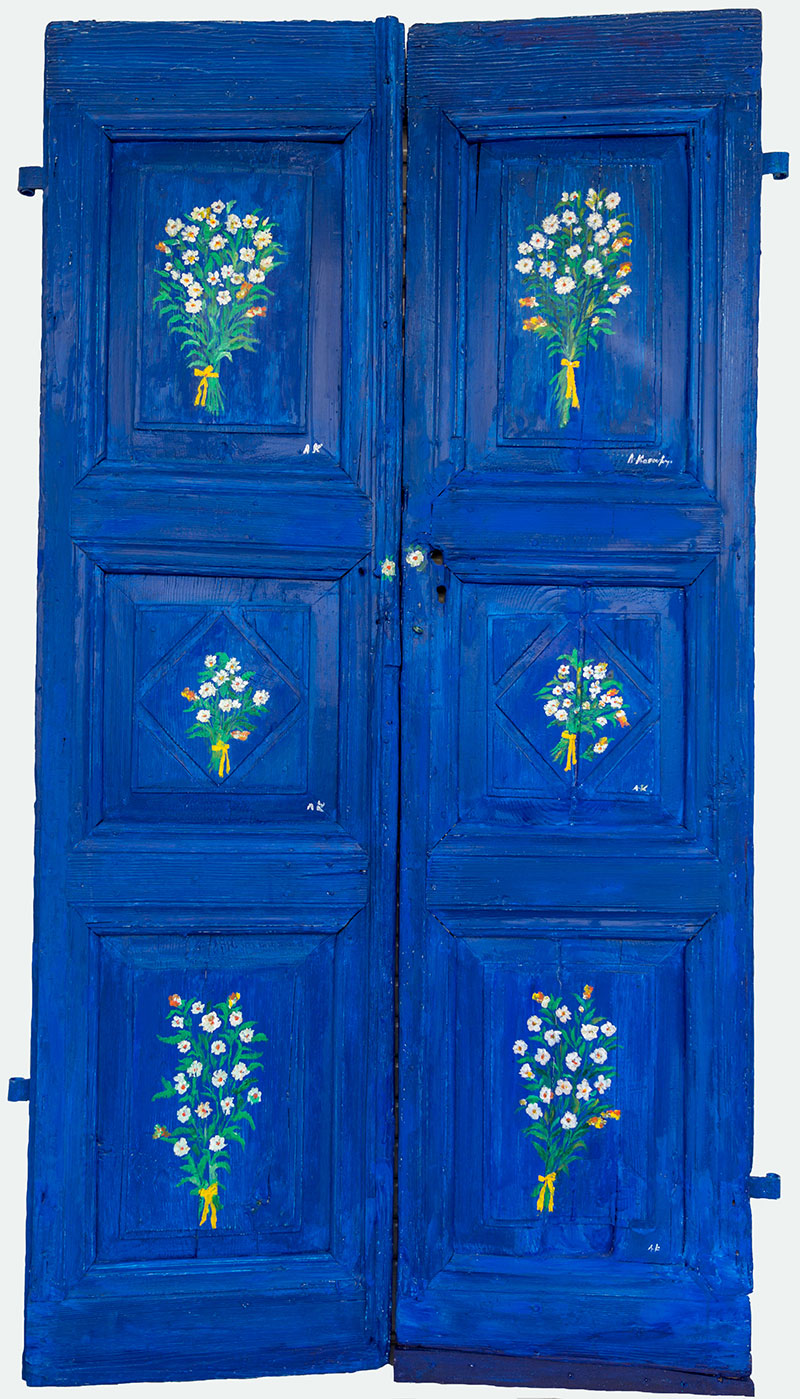 Πόρτα μπλε με μπουκέτα λουλουδιών
